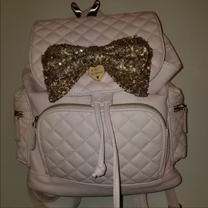 Pale pink backpack with a gold sequin bow